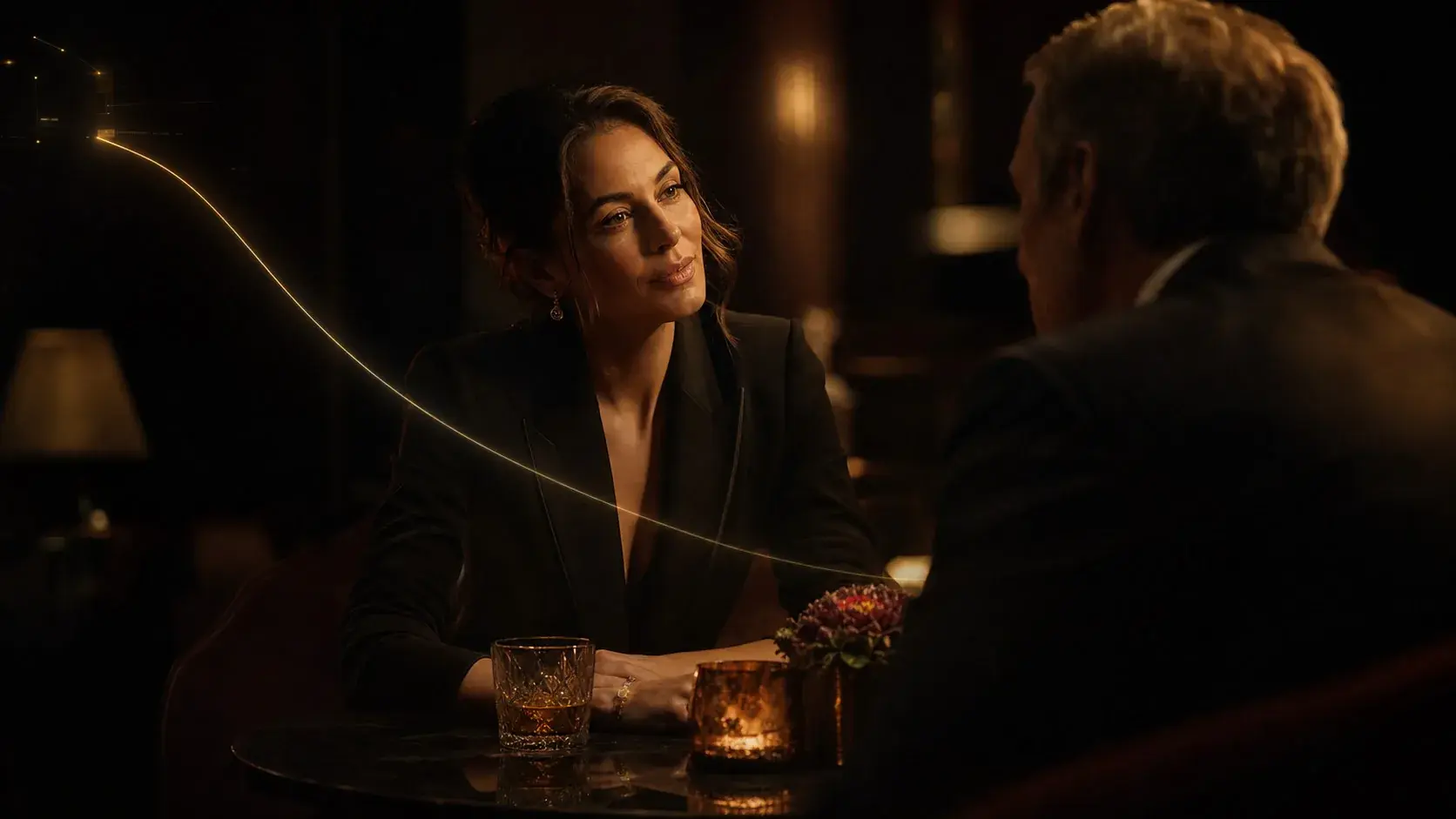 A master casino host reading a single guest across a candlelit table, a subtle gold thread of intelligence connecting them